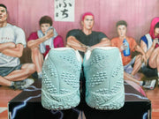 Pair of pale blue Nike basketball shoes shown from the heel, highlighting the textured outsoles.