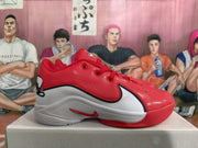 Side view of a red and white basketball shoe with black outlined detailing