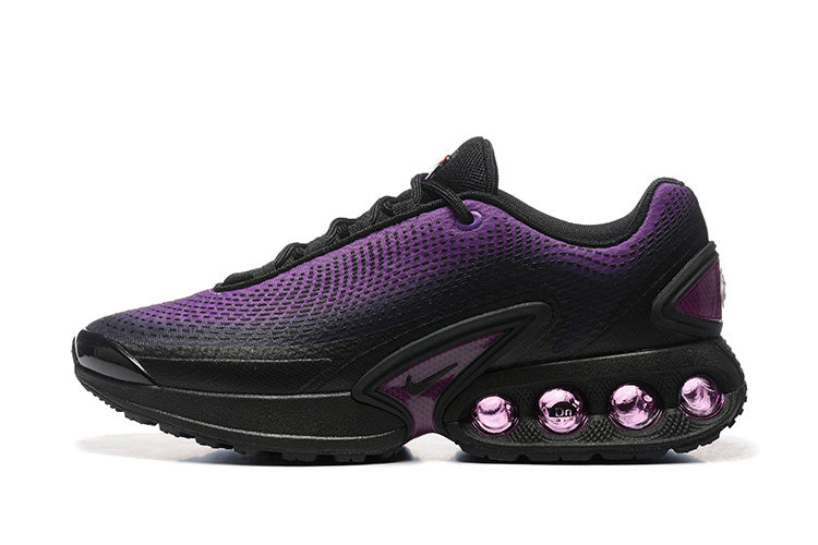 Side view of black and purple Nike Air Max DN sneakers with purple cushioning elements in the sole
