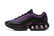 Side view of black and purple Nike Air Max DN sneakers with purple cushioning elements in the sole
