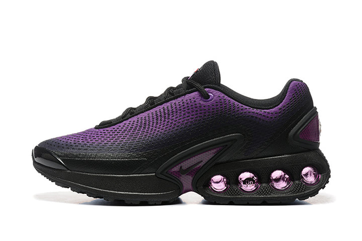 Side view of black and purple Nike Air Max DN sneakers with purple cushioning elements in the sole