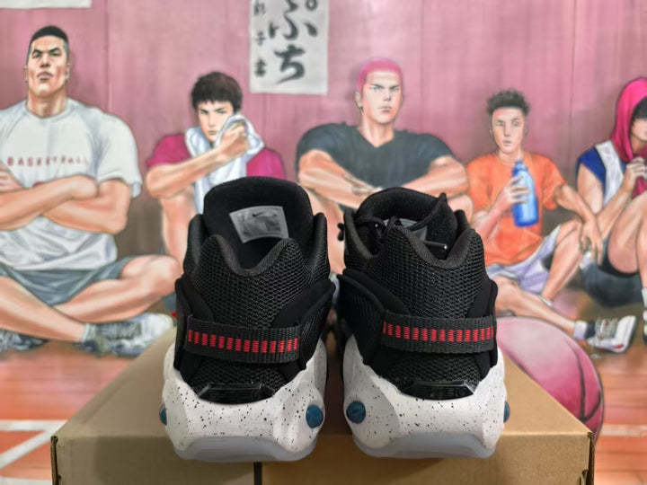 Rear view of black sneakers with red heel straps, white speckled midsoles, and blue cushioning windows.