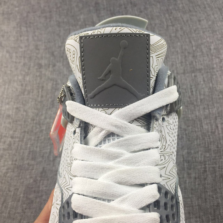 Close-up of the Jordan Air Jordan 4 tongue, white laces, gray tongue panel, and graphic-patterned upper.