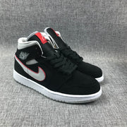 Three-quarter view of the black, silver and red mid-top sneaker pair.