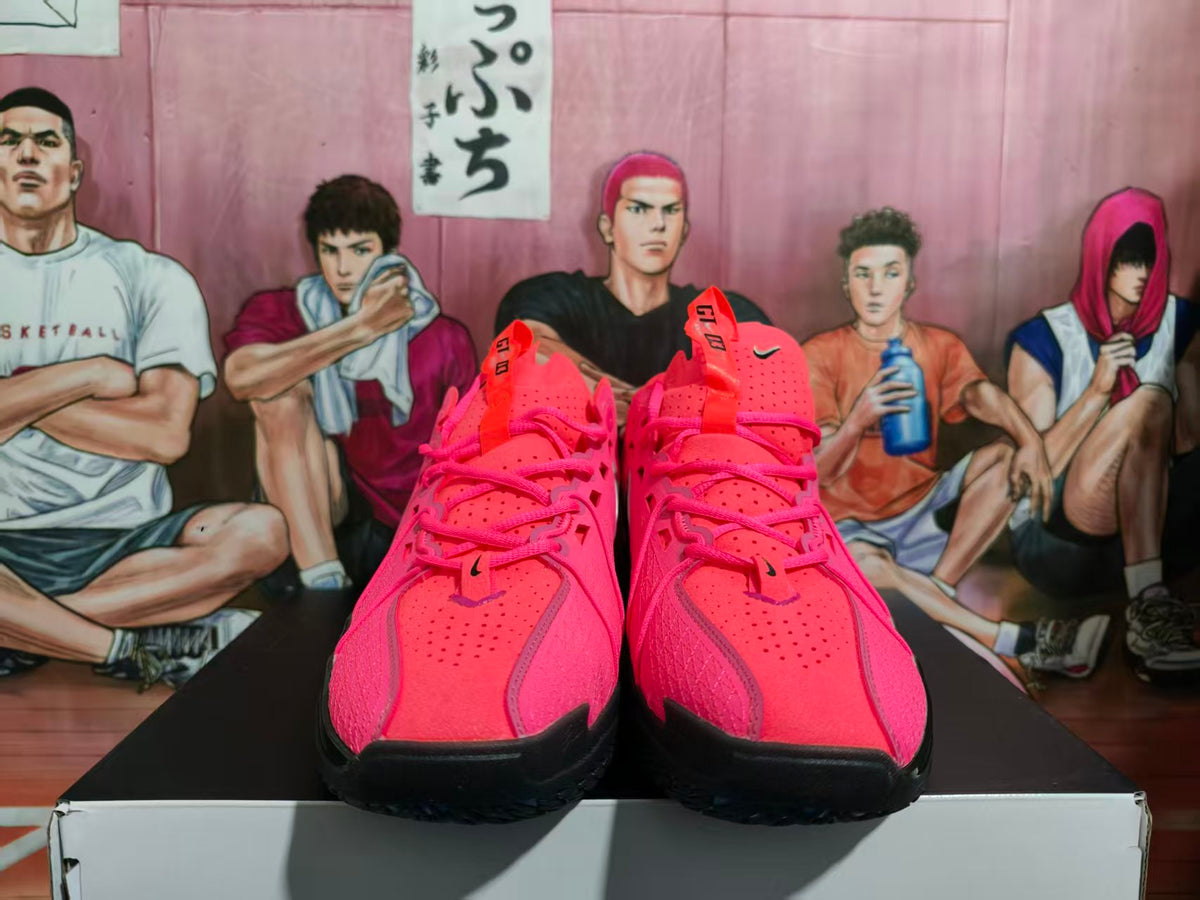 Front view of bright pink Nike basketball sneakers with black outsoles and pink laces, displayed on a box.