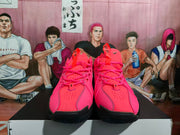 Front view of bright pink Nike basketball sneakers with black outsoles and pink laces, displayed on a box.