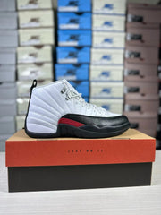 Side profile of the white, black and red Jordan Air Jordan 12 sneaker on a shoebox.