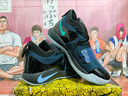 Angled view showing the side logos, glossy panels, straps and speckled detailing on Nike basketball shoes.