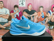 Side view of a blue Nike Kobe-style basketball shoe with white swoosh and outsole