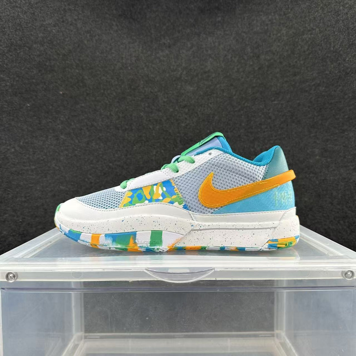 Side view of a blue, white, and yellow low-top Nike sneaker with green laces and a multicolored outsole.