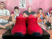 Front view of the red Nike basketball sneakers with laces, textured uppers, and the number 20 on the dark toe sections.