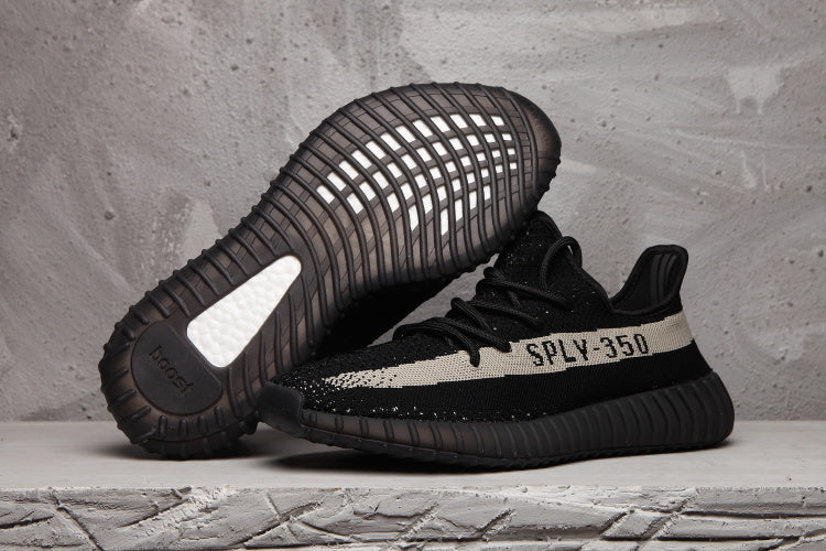 Side view of black SPLY-350 sneakers, with one shoe showing the ribbed outsole.