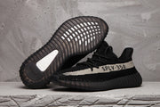 Side view of black SPLY-350 sneakers, with one shoe showing the ribbed outsole.