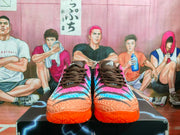Front view showing the brown laces, colorful textured uppers, and orange outsoles.