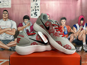 Pair of gray Nike sneakers with red graphic details and white ridged soles.