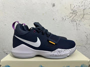 Side view of a navy Nike PG 1 basketball shoe with a white Swoosh and speckled midsole