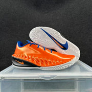 Orange and blue Nike GT basketball shoe shown beside its white outsole