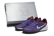 Pair of purple and burgundy Nike Kobe-style basketball shoes with white floral Swooshes beside a shoebox