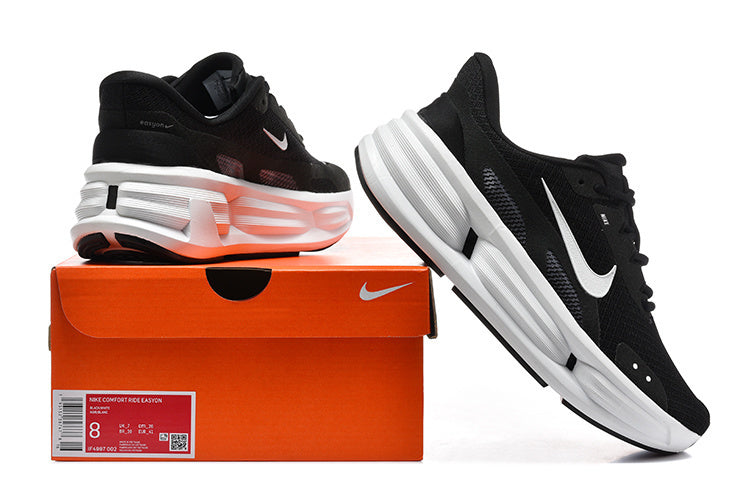Black Nike Comfort Ride EasyOn sneakers with white Swoosh details displayed beside an orange shoe box; the box label shows sample size 8.