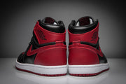 Rear view of black and red high-top sneakers showing red heel panels, black collars, ankle branding, and white midsoles.
