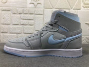 Lateral side view showing the high-top silhouette, gray upper, pale blue Swoosh, laces, and layered sole.