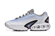 Side view of white and light blue Nike Air Max DN sneakers with black accents and circular midsole details.
