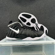 Angled view of black Nike sneakers showing the white Swoosh, molded upper and outsole traction sections.