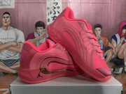 Angled product view of two pink Jordan basketball sneakers showing the side detailing, metallic-gold accents, lace-up construction, and padded collars.