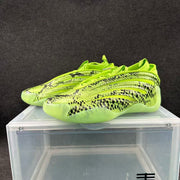 Pair of lime-green low-profile sneakers with black snake-like patterning, shown from the side