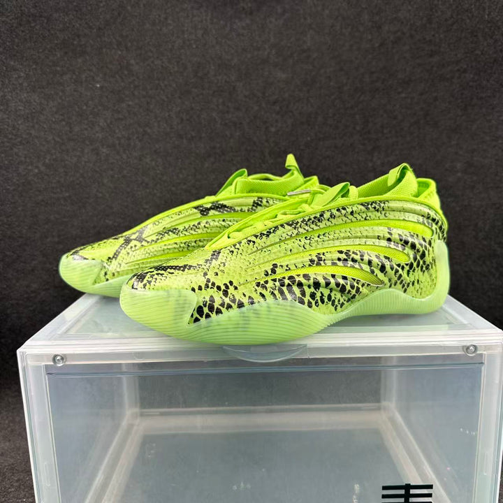 Pair of lime-green low-profile sneakers with black snake-like patterning, shown from the side