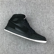 Angled single-shoe view showing the black upper, mid-top collar and white outsole.
