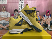 Pair of yellow and black high-top sneakers displayed diagonally on a yellow shoebox, showing the side panels, mesh inserts, lace supports, and white midsoles.
