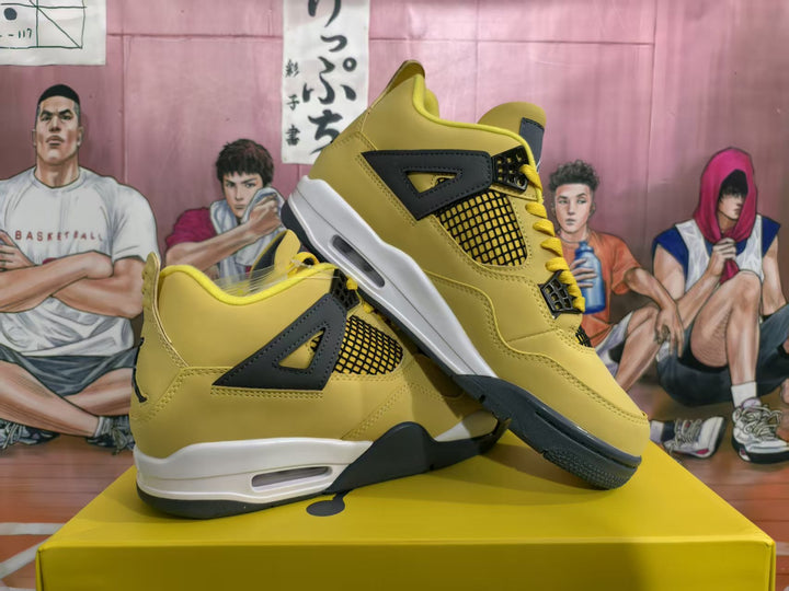 Pair of yellow and black high-top sneakers displayed diagonally on a yellow shoebox, showing the side panels, mesh inserts, lace supports, and white midsoles.