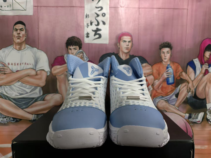 Front view of Carolina blue and white Nike basketball sneakers with white laces and a basketball-style signature logo on the tongues.