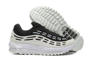 Side view of the sneakers with one shoe turned to show the patterned outsole