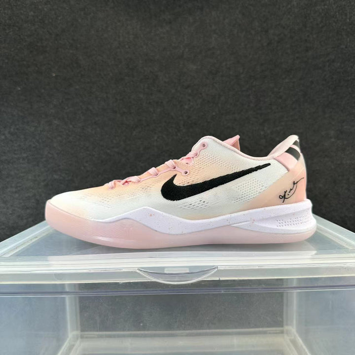 Side view of a white and pink low-top Nike basketball sneaker with a black Swoosh.
