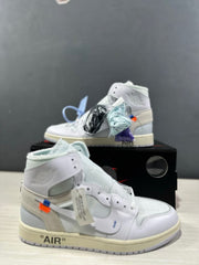 Angled view of the sneaker pair with additional black, light blue, and purple lace sets.