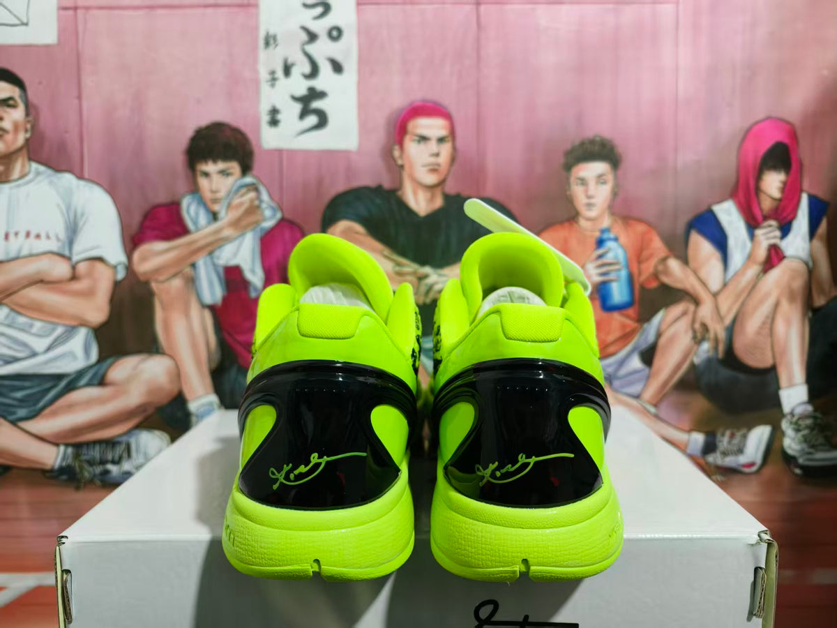 Rear view of bright green and black sneakers showing glossy black heel panels and green outsole details.
