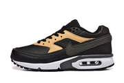 Side view of a black and tan Nike Air Max sneaker with a white midsole and heel air unit.