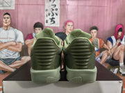 Rear view of the green sneakers showing ribbed heel panels and textured outsole sections.