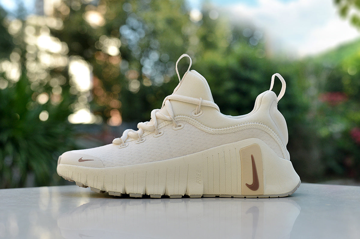 Cream Nike low-top sneaker with brown-toned Swoosh details and a chunky grooved sole