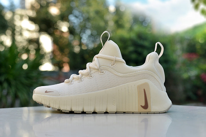 Cream Nike low-top sneaker with brown-toned Swoosh details and a chunky grooved sole