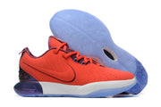 Coral red Nike basketball shoe with purple and blue accents.
