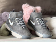 Pair of gray high-top sneakers viewed from the front, with laces, ankle straps and contrasting toe and sole sections visible.