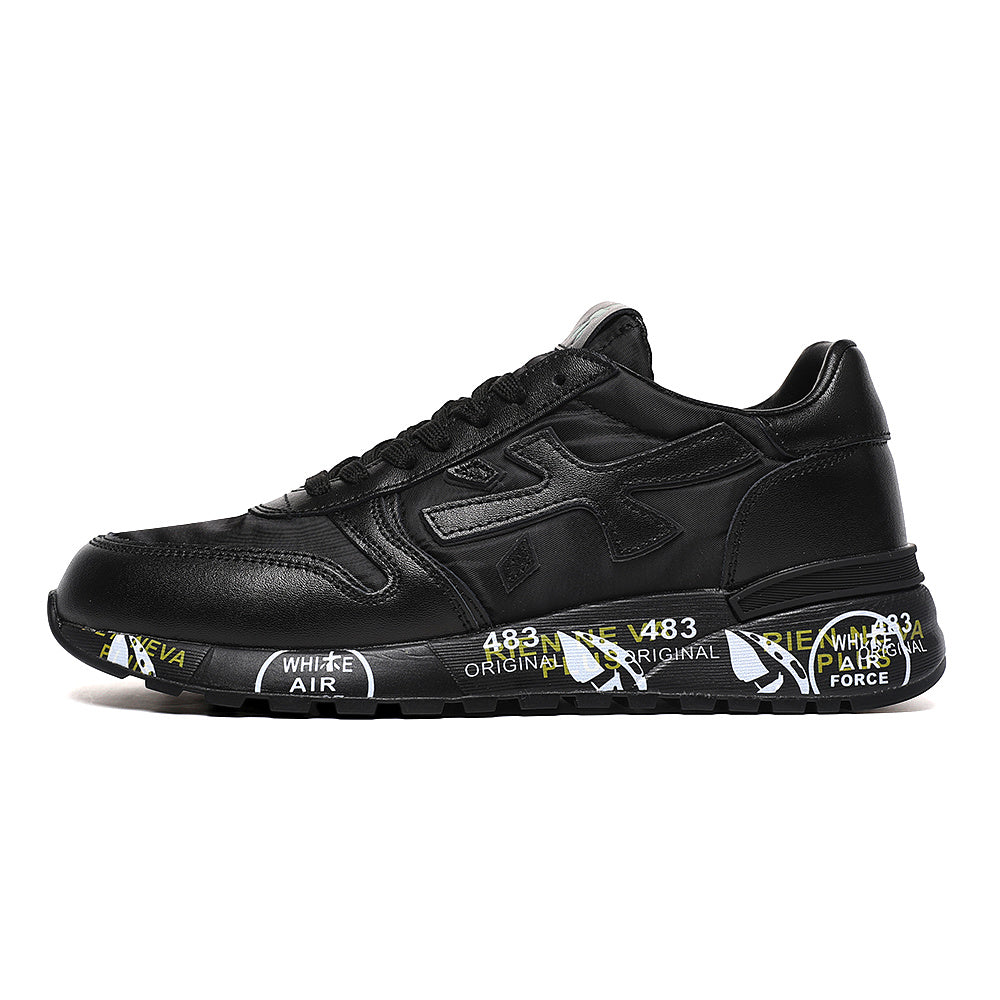 Side view of a black Premiata low-top sneaker with lace-up closure, a side logo and a raised sole featuring contrasting printed graphics.
