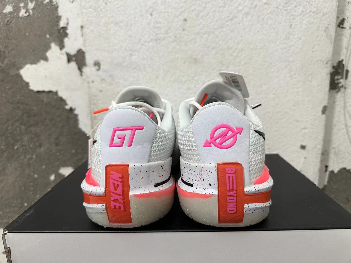 Rear view of white Nike basketball shoes with pink heel accents and speckled midsoles