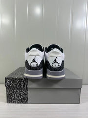 Rear view of white and grey Air Jordan 3 sneakers displayed on a patterned shoebox.