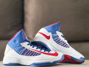 Pair of white, blue, and red Nike high-top sneakers shown from angled side views.