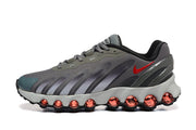 Side view of gray Nike Air Max DN sneakers with red Swoosh accents and sculpted cushioning.