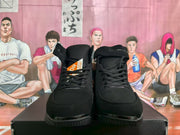 Front view of black high-top sneakers with laces, padded tongues, tonal detailing and textured rubber toe sections.